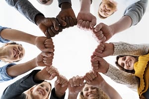 un grand cercle de personnes vues d’en haut, mains liées